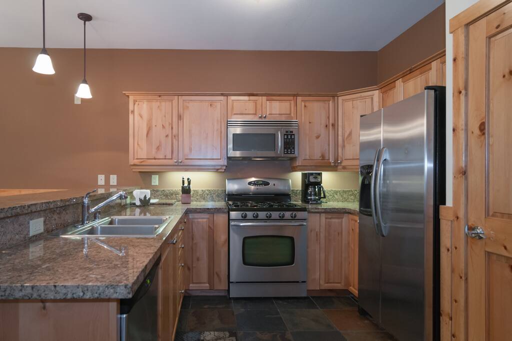 Well equipped kitchen includes granite counter tops and stainless steel appliances.