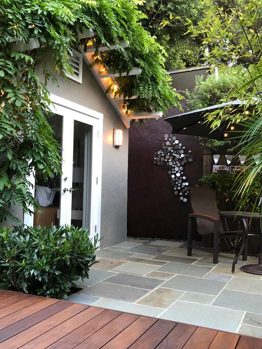 Front entrance of the guest house, with an outdoor table and chairs for working, drinks, or a meal.