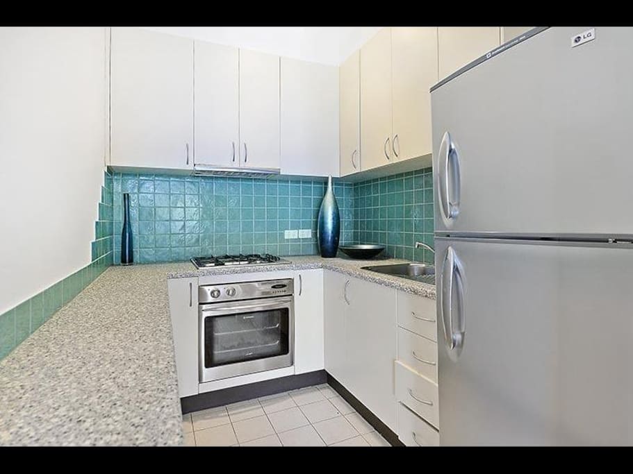 Modern gas kitchen with stainless steel appliances, fully equipped with utensils, kettle, toaster and Magic bullet.