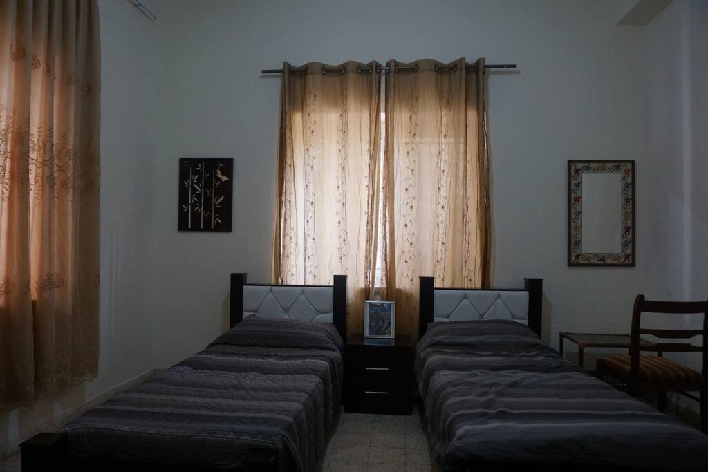 Spacious bedroom with 10ft ceiling, 2 single beds, plenty of closet space, night stand, dresser and mirror