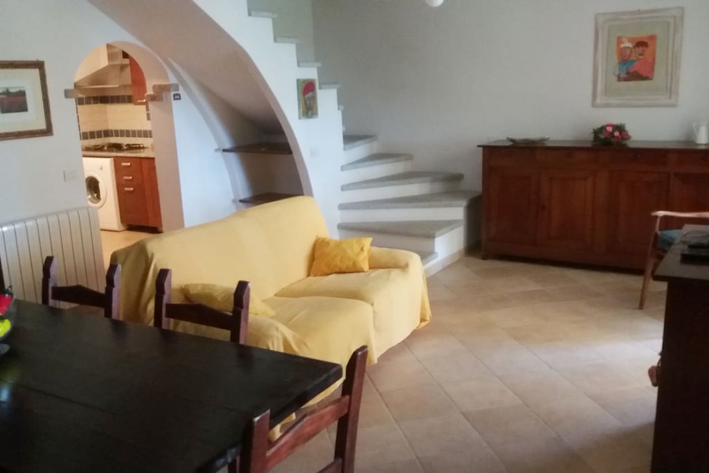 Il soggiorno con l' elegante scala in granito bocciardato. Il piano superiore è chiuso e completamente separato da un soppalco nel vano scala, poiché abitato dal proprietario.
