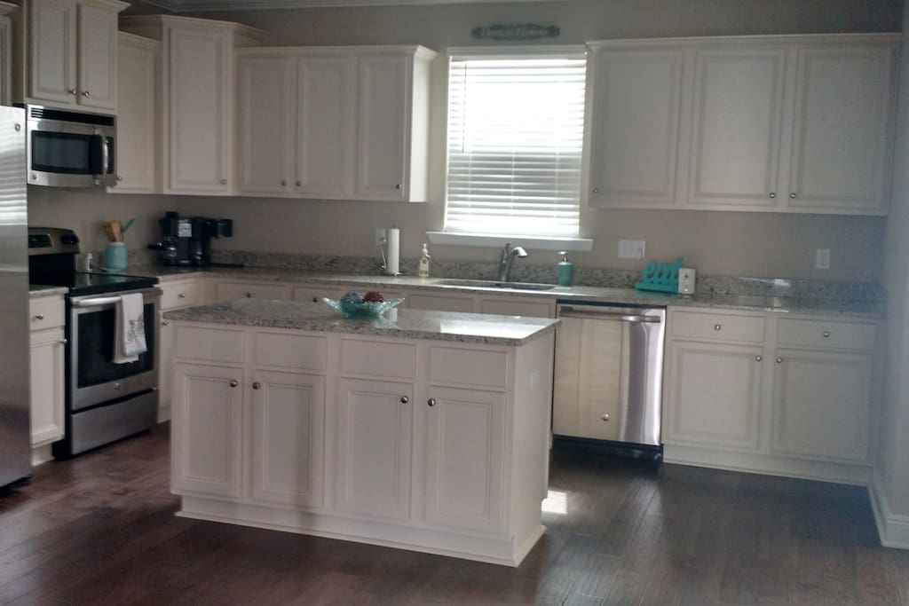 Huge open kitchen with all cooking supplies including pots, pans, toaster, coffee pot, plates, utensils, etc.