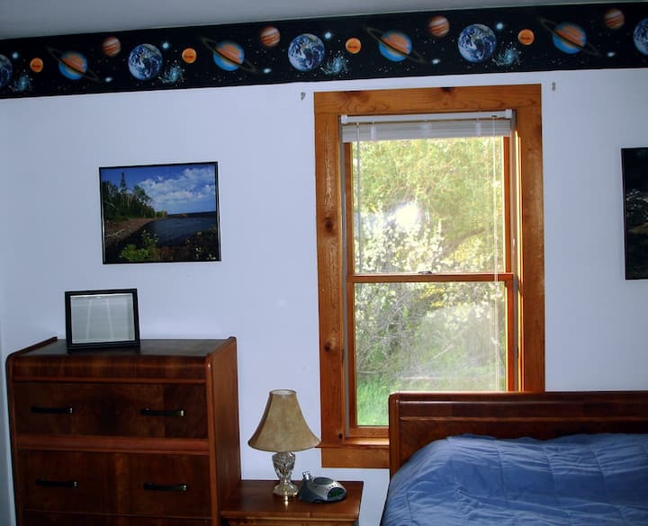 Спалня на долния етаж с галактика от звезди на тавана.