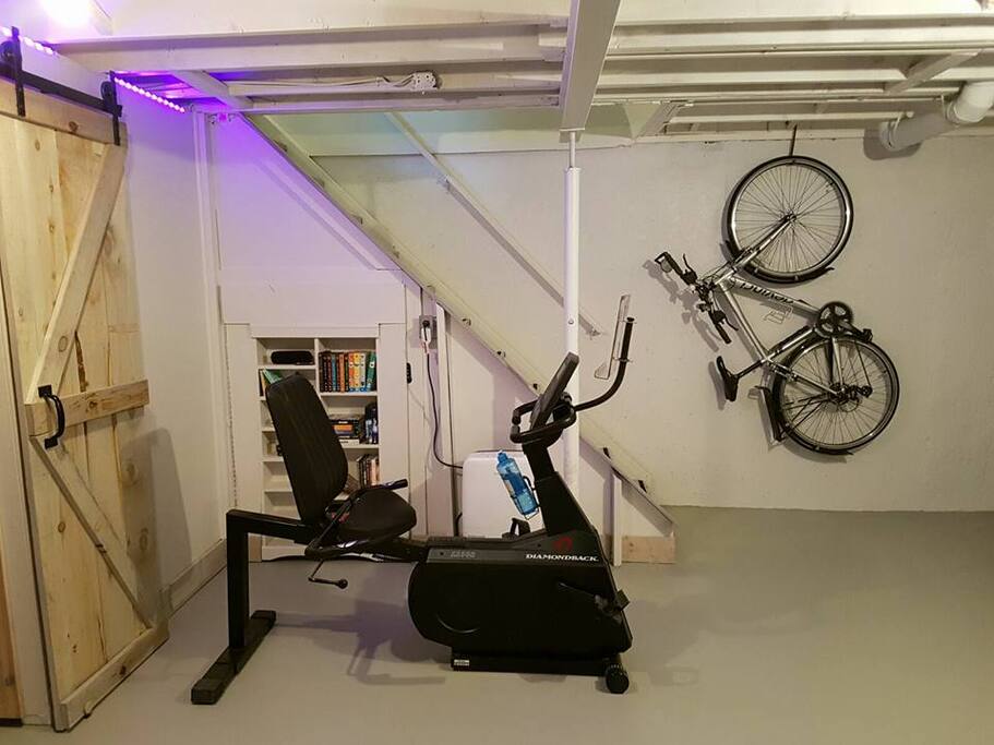 The basement gym includes light free weights, a recumbent bicycle, and an elliptical. There is also a large TV and a ping pong table.