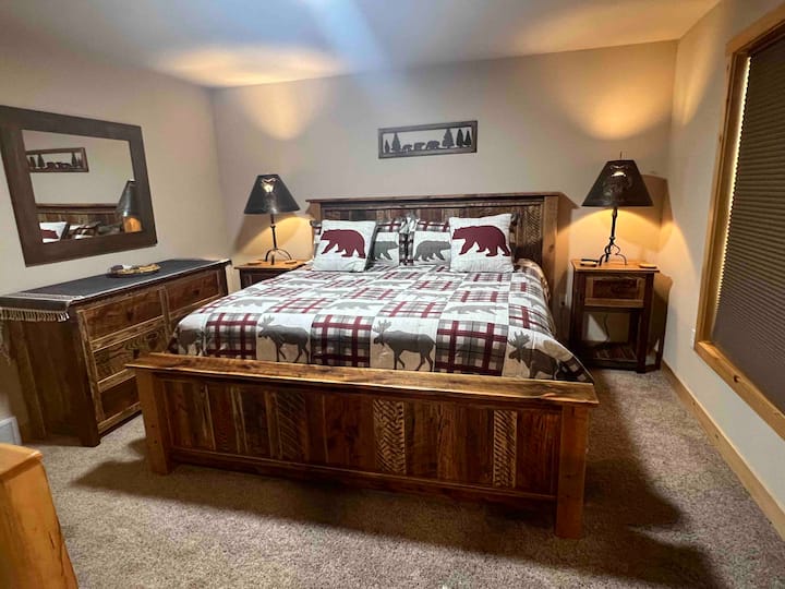 Dormitorio 1, con cama tamaño king y muebles de granero recuperados personalizados, y baño adjunto / en suite.