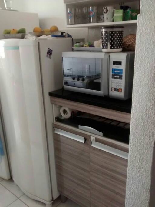 Cozinha com microondas, geladeira e fogao