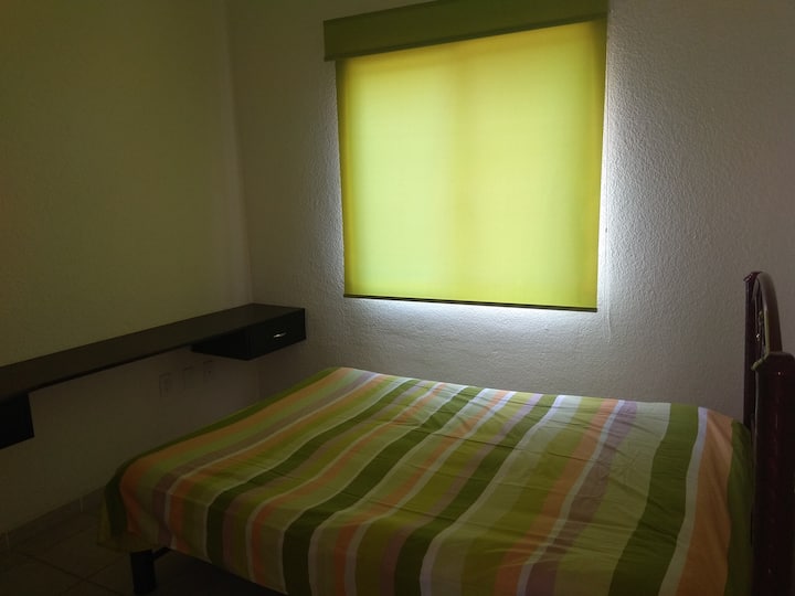 Спална соба со двоен кревет со перници и плакар