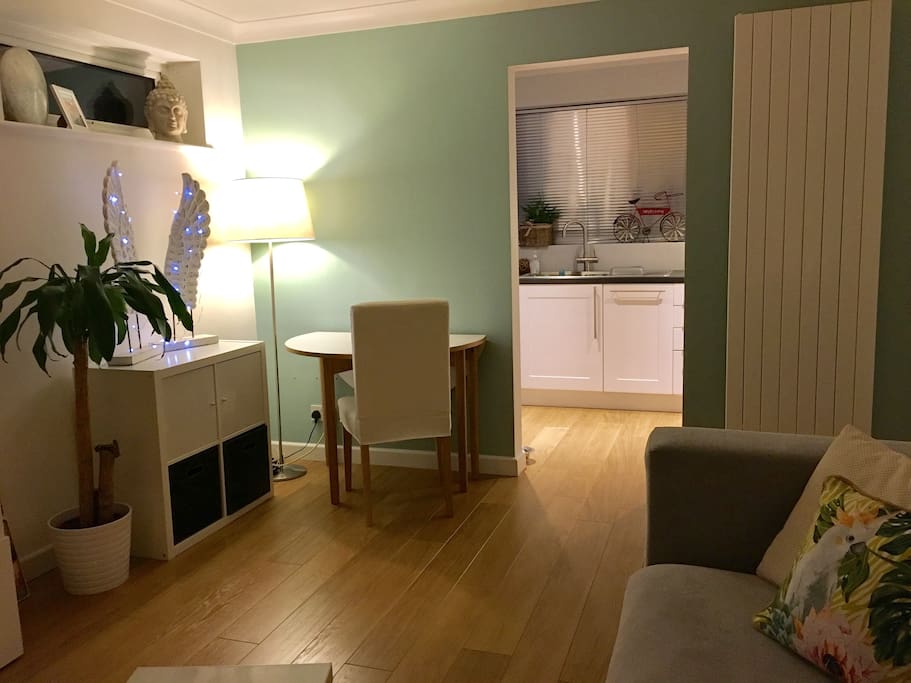 Living area with large sofa, TV and dining table