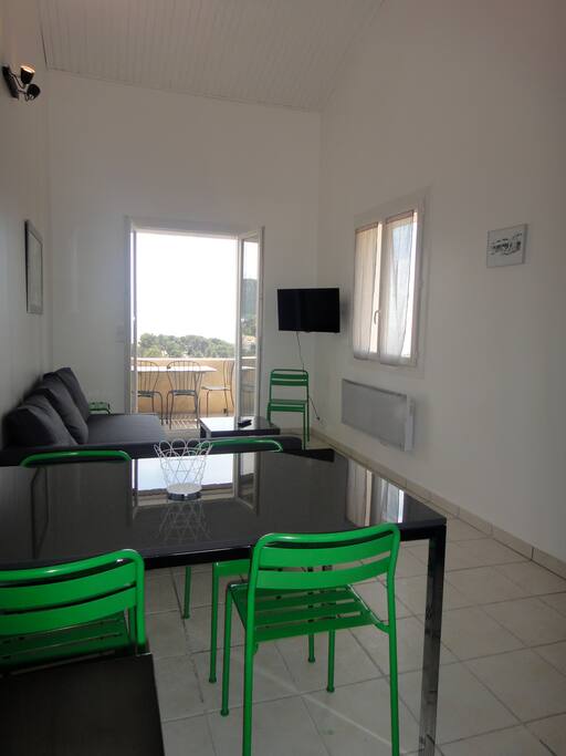 Coin repas avec salon, petit balcon avec vue mer