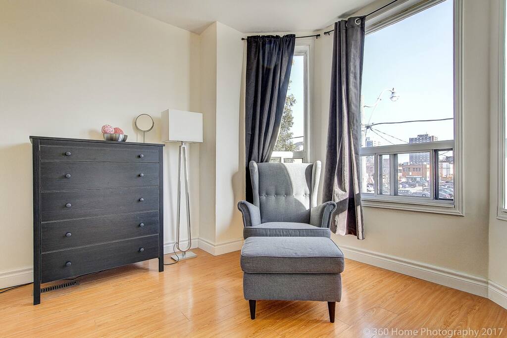 All windows have black out curtains (this room has noise cancelling black out curtains) Super comfy arm chair with foot stool (and little fake plant). Enjoy a nice read on this one.