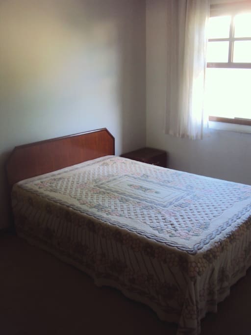 Quarto com janela para o jardim e árvores