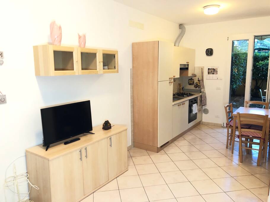 Soggiorno e cucina con porta finestra su giardino privato