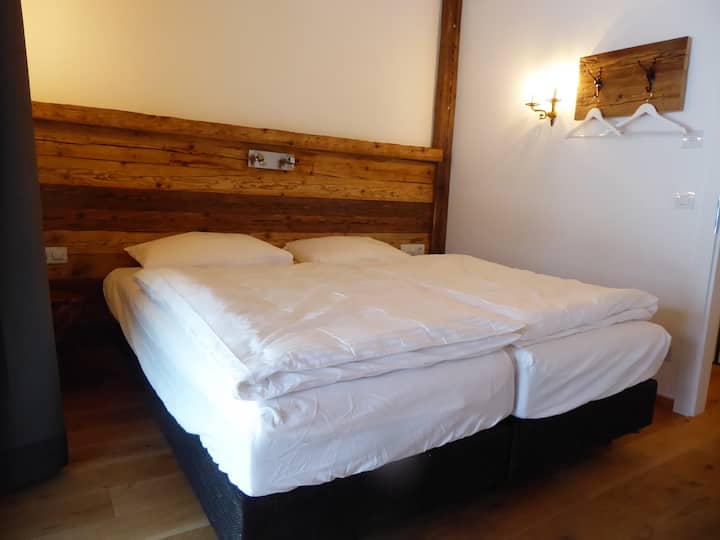 หนึ่งในสามห้องนอนคู่ตกแต่งด้วยวอลล์เปเปอร์ไม้ประวัติศาสตร์ 