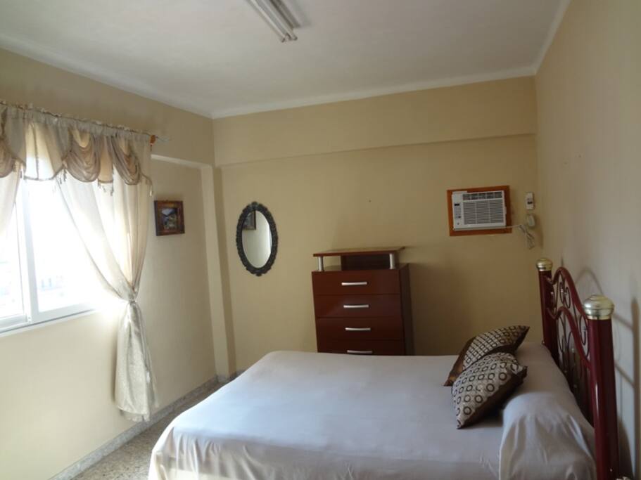 Habitación 1. Tiene una excelente iluminación y ventilación natural, al punto de que muchos huéspedes no encienden el aire acondicionado. Está habilitada además con una cama matrimonial, gavetero, closet y nevera.