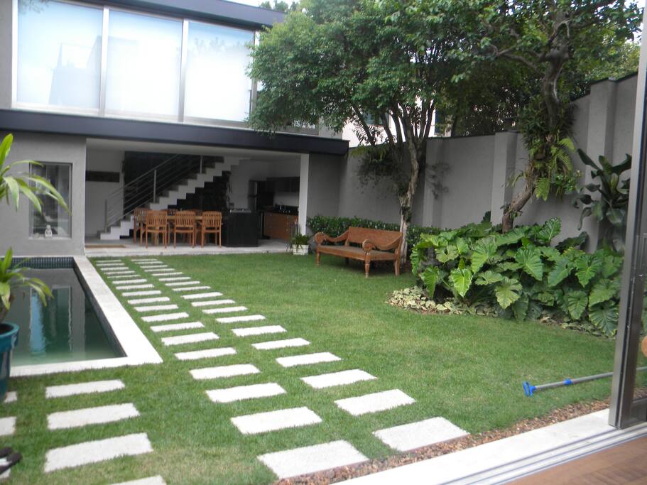 vista da cozinha gourmet ao fundo , com amplo jardim e piscina