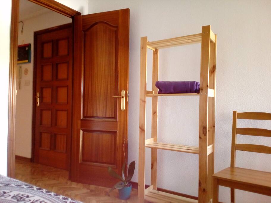 Están unas estanterías, una silla y un mueble pequeño con 2 cajones a tu disposición.