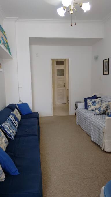 Sala com dois ambientes, sofá cama, ventiladores e ar condicionado