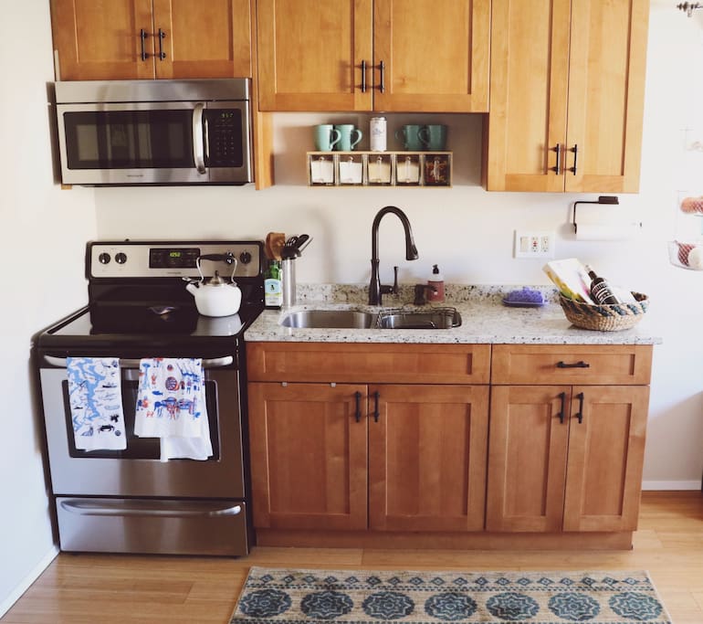 The kitchen has stainless steel appliances, granite countertops, a double sink, full refrigerator and freezer, and all the essentials for cooking, baking, tea and coffee