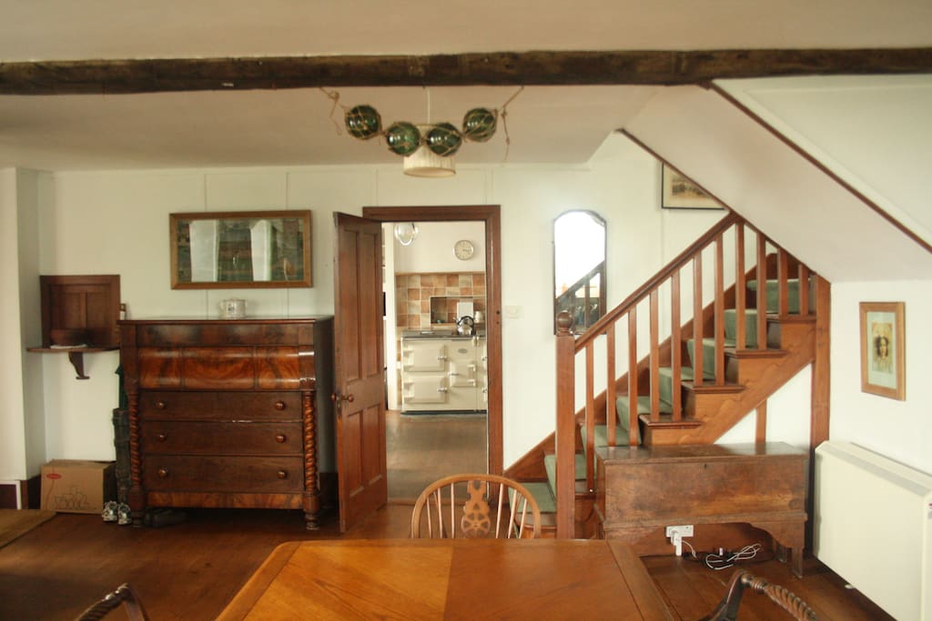View of the glorious aga from the dining room, and serving hatch on the left. Stairs up to the second floor.