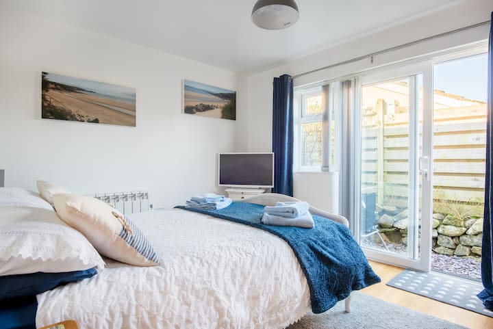 חדר שינה כפול עם דלתות פטיו המובילות לאזור ישיבה פרטי בחוץ