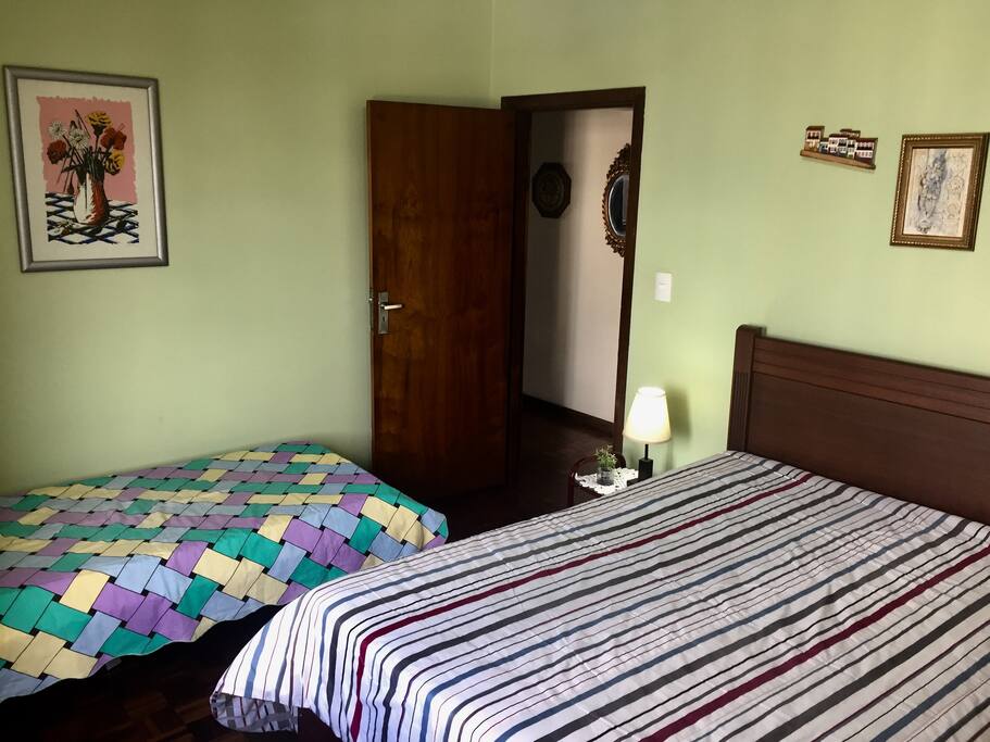 Quarto com uma cama de casal e uma de solteiro
