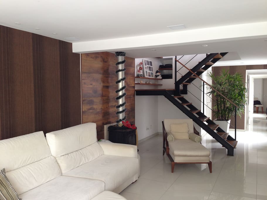 Ampla sala de estar com lareira, TV 52", som ambiente e split.