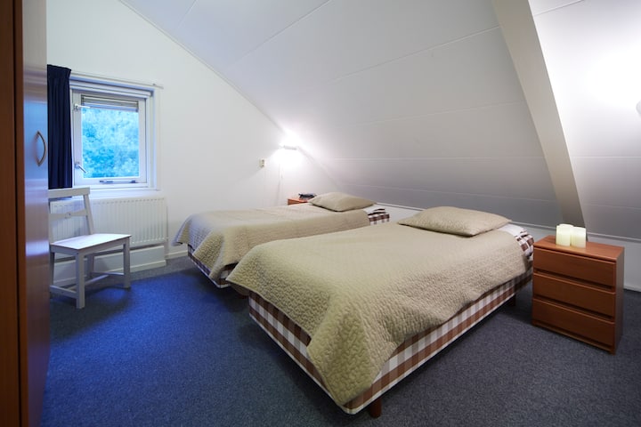 À l'étage : 1 des 3 chambres avec 2 lits simples (de Hästens dans cette chambre) qui peuvent facilement être poussés jusqu'à 1 lit double.