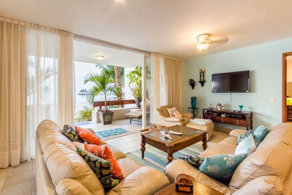 The living room has two comfortable couches and a 55 inch flat screen TV with lots of English channels