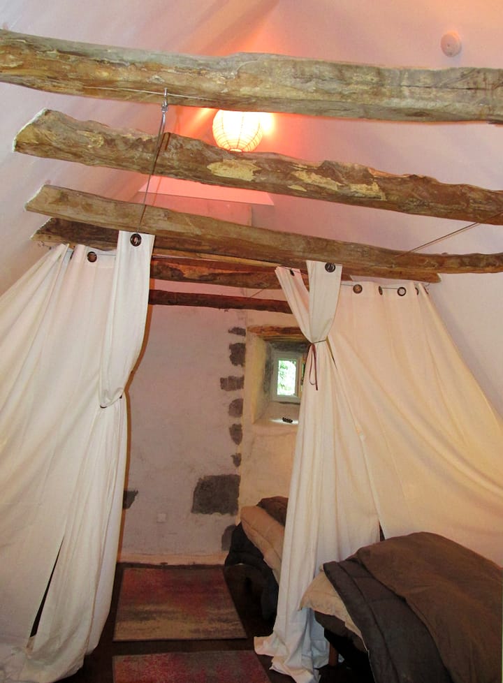 Спалнята под тавана с 4 помещения, разделени от завеси.