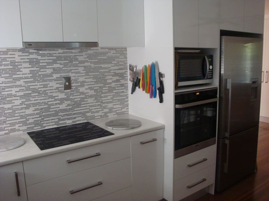 Induction cook-top, range-hood, convection microwave and fridge with iced water and ice maker.
