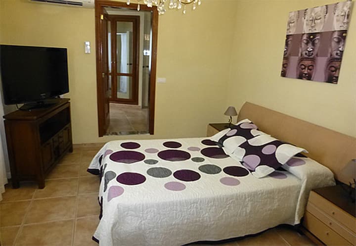 Soba s bračnim krevetom i kupaonicom u spavaćoj sobi u pozadini