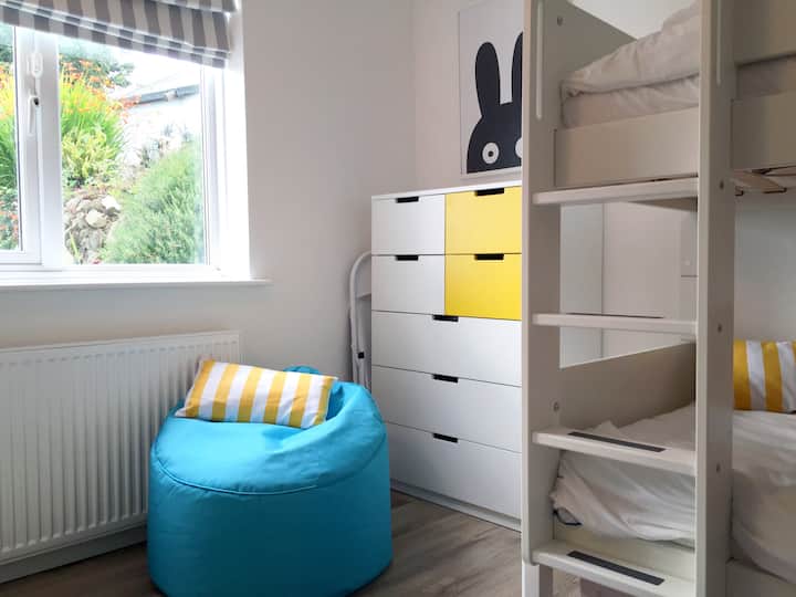 Детска стая с двойно легло в пълен размер и достатъчно място за съхранение.