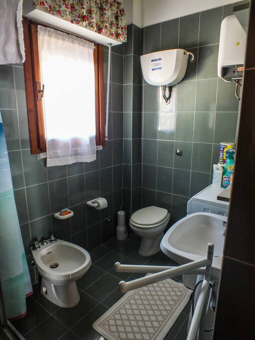Il bagno completo di lavandino, specchio, water, bidet, doccia e lavatrice