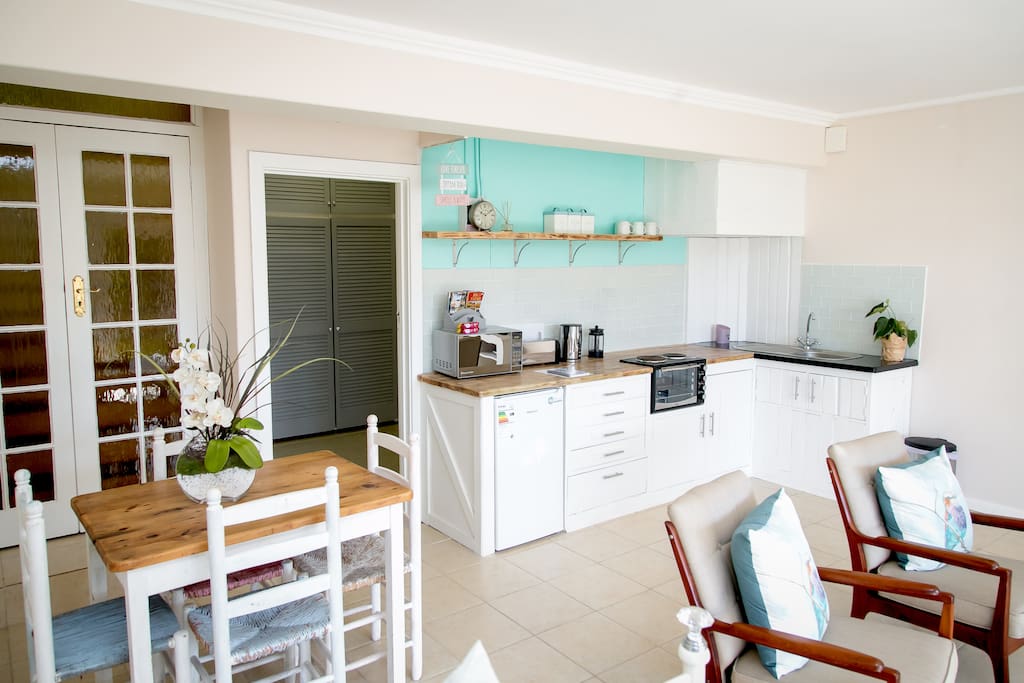 Our self catering kitchen, which always includes water, milk, orange juice, tea, coffee, sugar, eggs, biscuits and a bottle of champers/beer to welcome you!
We also have a fab dining table for you to sit indoors and have breakfast etc.