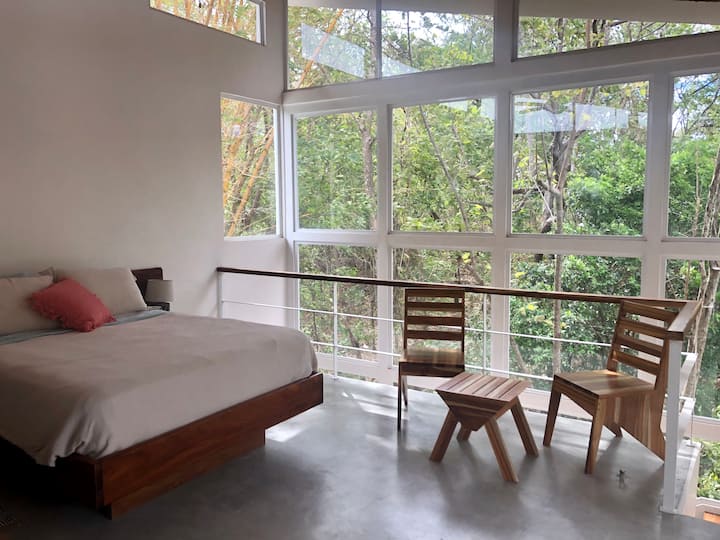 חדר שינה ראשי עם נוף לג'ונגל.