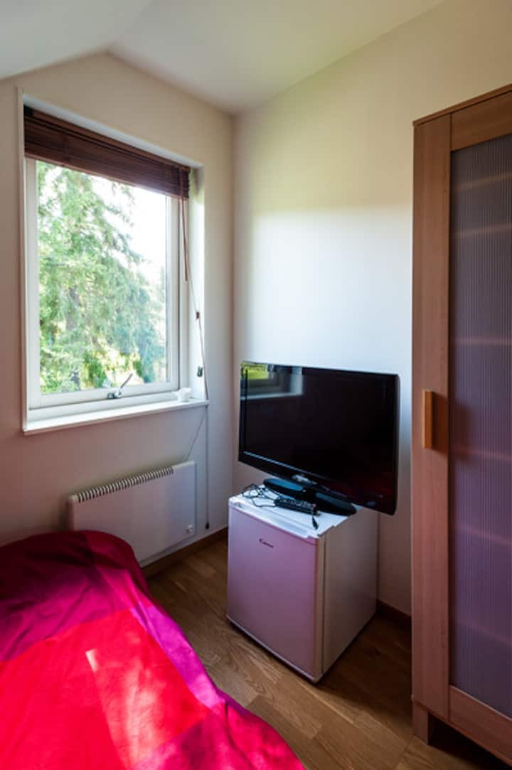 Kleine slaapkamer met tweepersoonsbed op de bovenste verdieping - met minikoelkast en tv