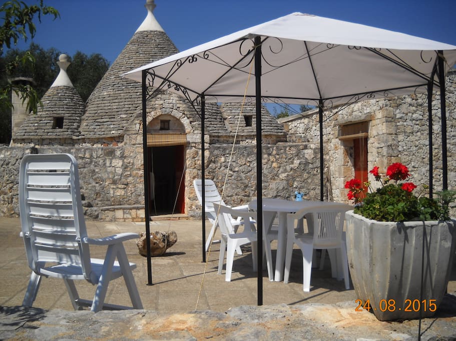 Rotonda antistante al trullo con gazebo tavolo e sedie