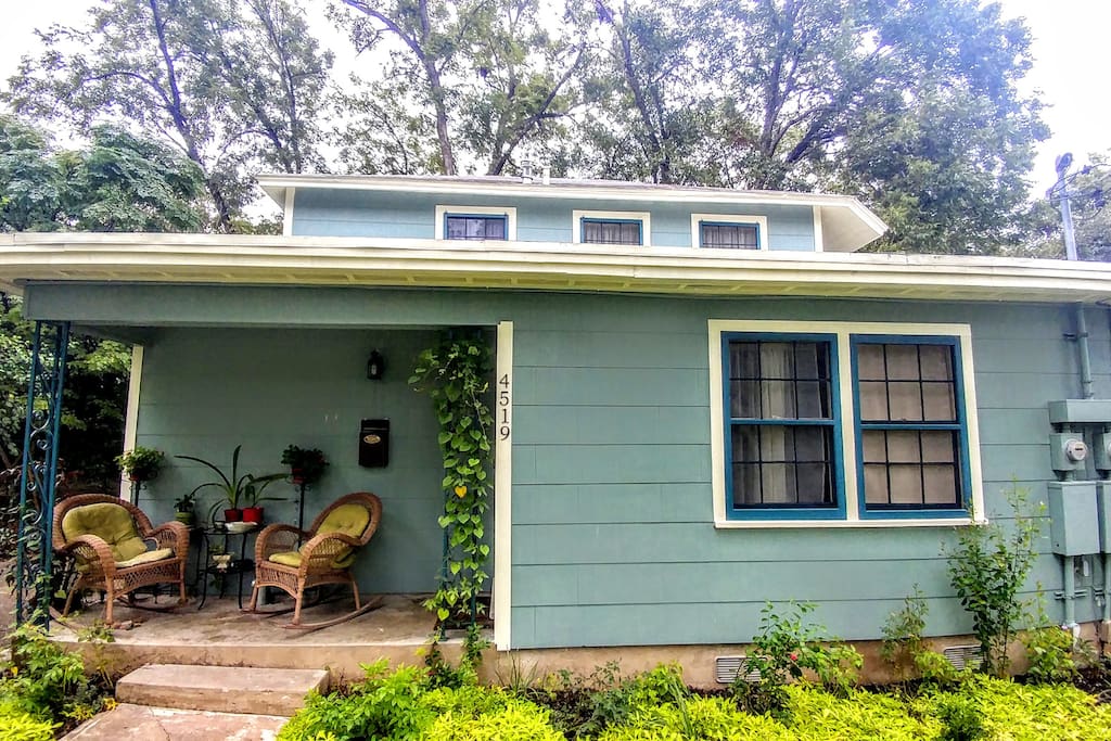 The house is nestled among a canopy of mature pecan trees.