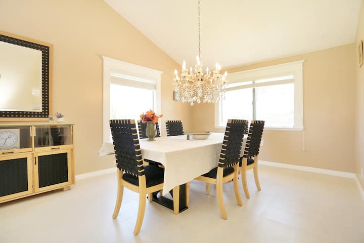 طاولة طعام تتسع لـ 6 مقاعد وطاولة مطبخ قريبة تحتوي على 3 مقاعد بار