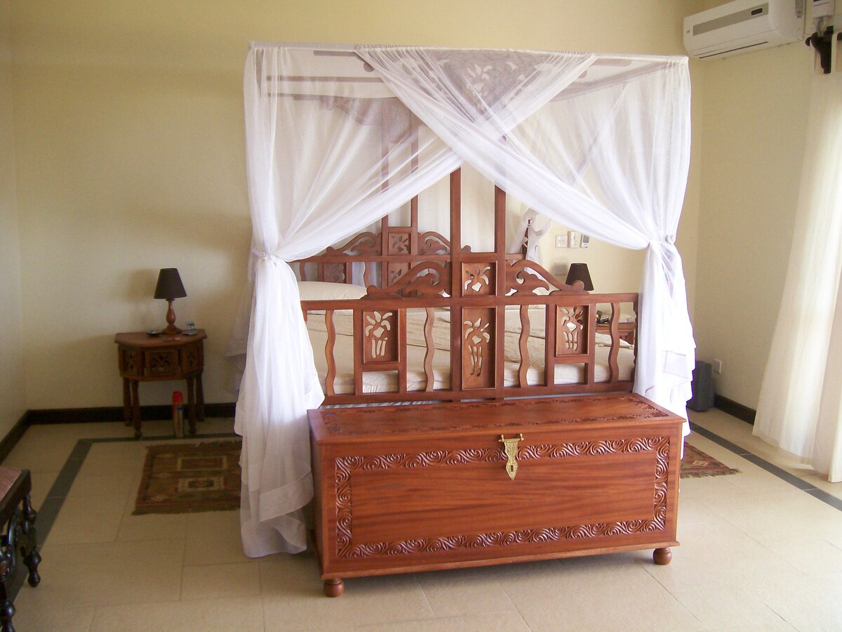 Camas estilo suajili y mosquiteras.