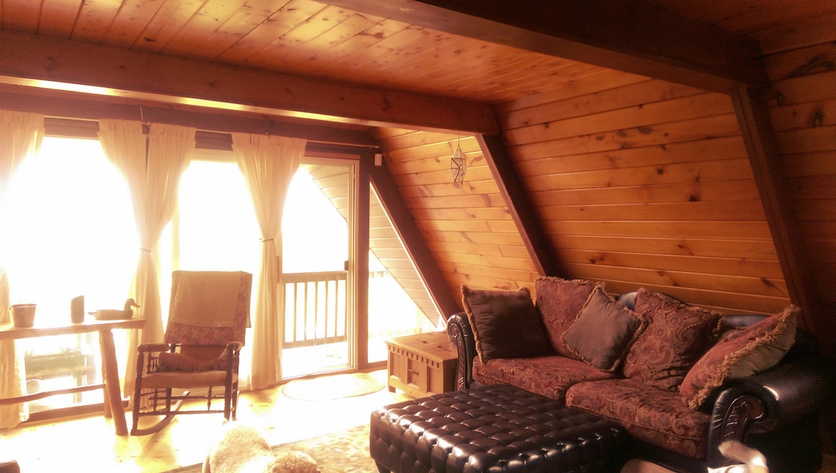 Woonkamer met bank, schommelstoel, overvolle stoel en smart-tv