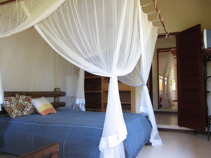 Habitación con cama doble y cama individual, con vistas al segundo dormitorio con 3 camas de una plaza.