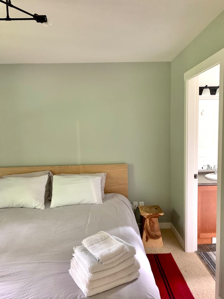 Dormitorio en la planta principal, con cama tamaño king, escritorio, lámpara de escritorio, TV y un gran armario. Se conecta con baño privado (baño de la planta principal). 