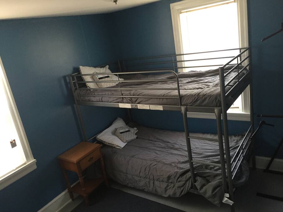 This room has no closet but it does have a hanging rack, their is also a dresser and w a mirror.