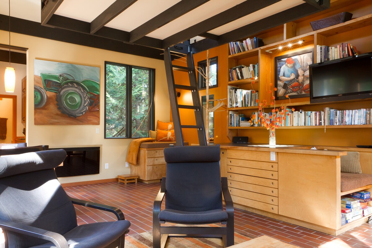 Zitplaatsen, ladder naar loft, raamzitje op de achtergrond, zithoek met spelletjes eronder op de voorgrond