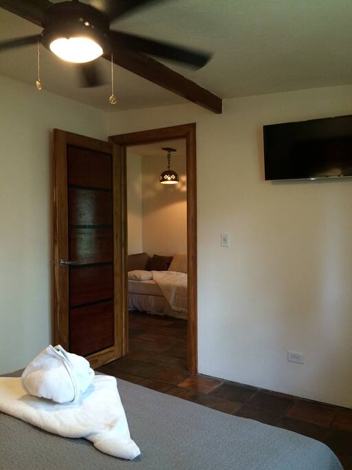 View from bed of the TV and the door to the living room space