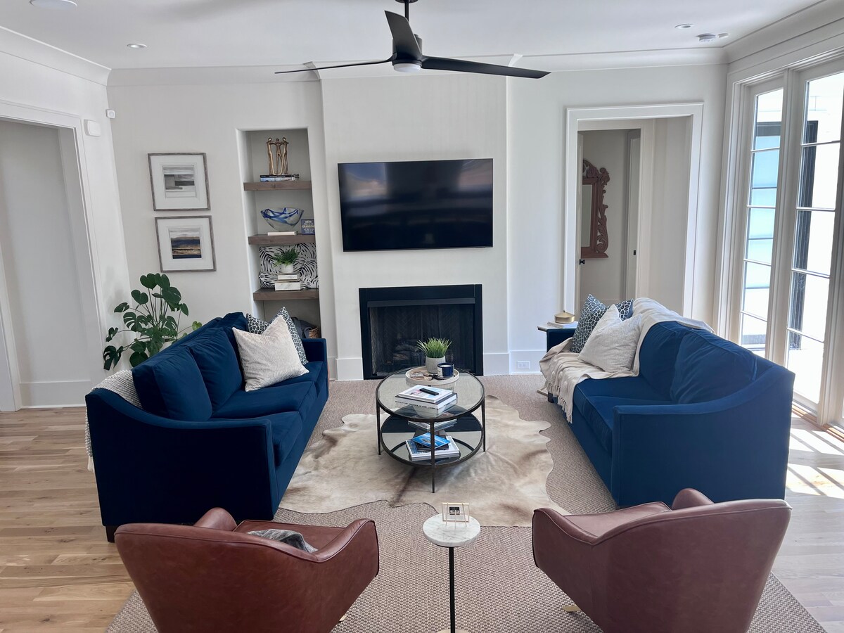 ห้องนั่งเล่นแบบเปิดโล่งพร้อมโซฟา 2 ตัว (ตัวหนึ่งเป็นแบบดึงออก) และเก้าอี้หนัง 2 ตัว