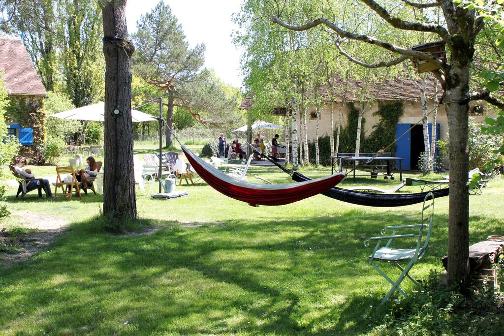 La cour, avec les hamacs, bains de soleil, fauteuils, parasol, ping-pong, boules...
