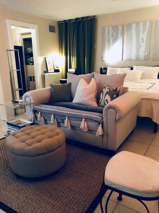 Seating area has plush loveseat and ottoman with black leather reading chair.