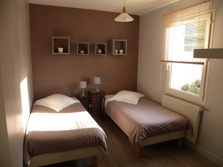 La chambre à deux lits, avec penderie et étagère de rangement.